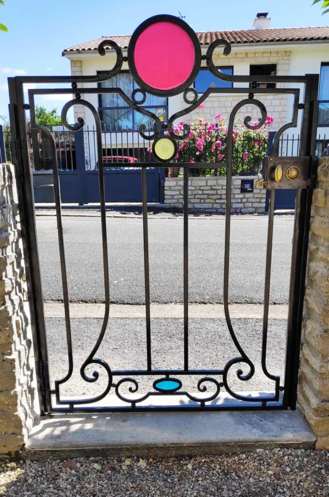 Portillon en fer forgé aux motifs colorés en résine d'Epoxy. Cet ouvrage a été réalisé par La Petite Enclume, entreprise de ferronnerie d'art et de métallerie fine en Côtes d'Armor